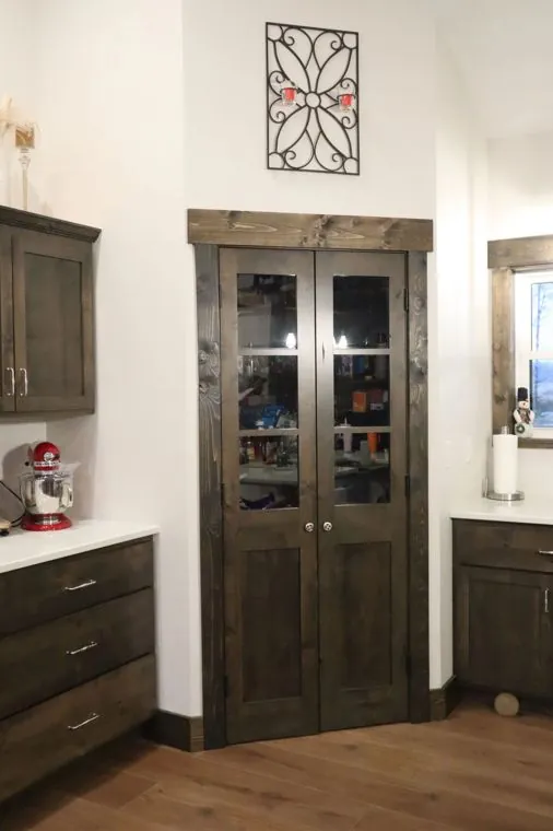 Stained alder pantry cabinet with glass display doors — built by Amish Heritage Woodworks, Wisconsin