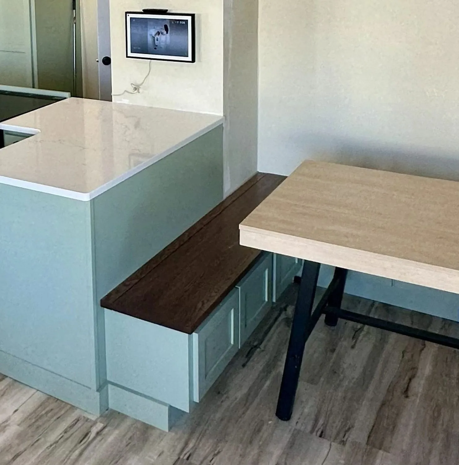 Built-in banquette bench seat in painted maple with a wood table